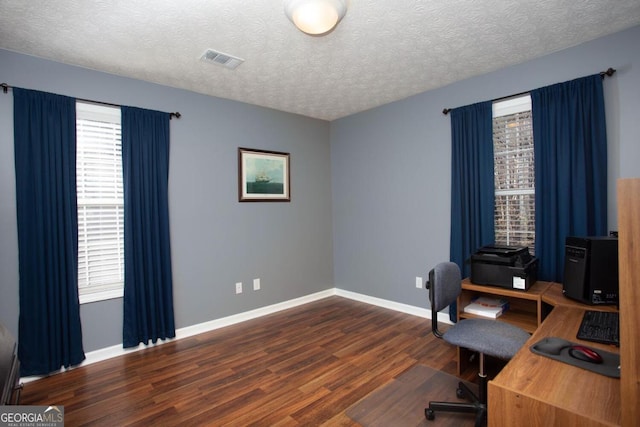 home office featuring dark wood-type flooring and a textured ceiling