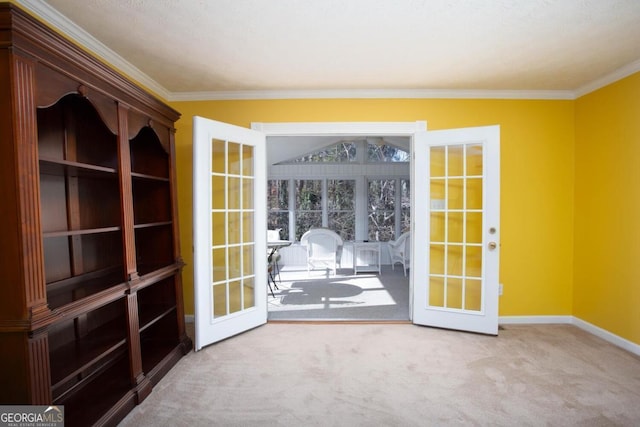 carpeted spare room with crown molding and french doors