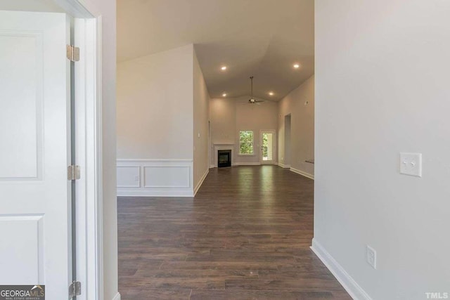 hallway featuring dark wood-type flooring and lofted ceiling