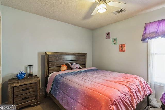 bedroom featuring ceiling fan and a textured ceiling