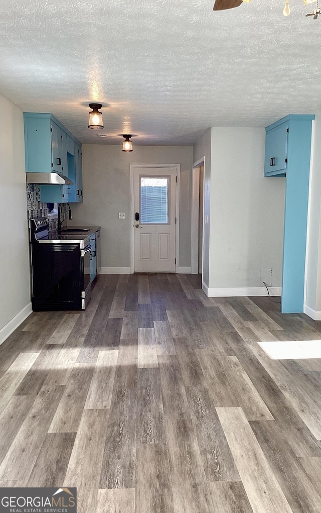 kitchen featuring a textured ceiling, black range with electric stovetop, blue cabinets, and hardwood / wood-style flooring