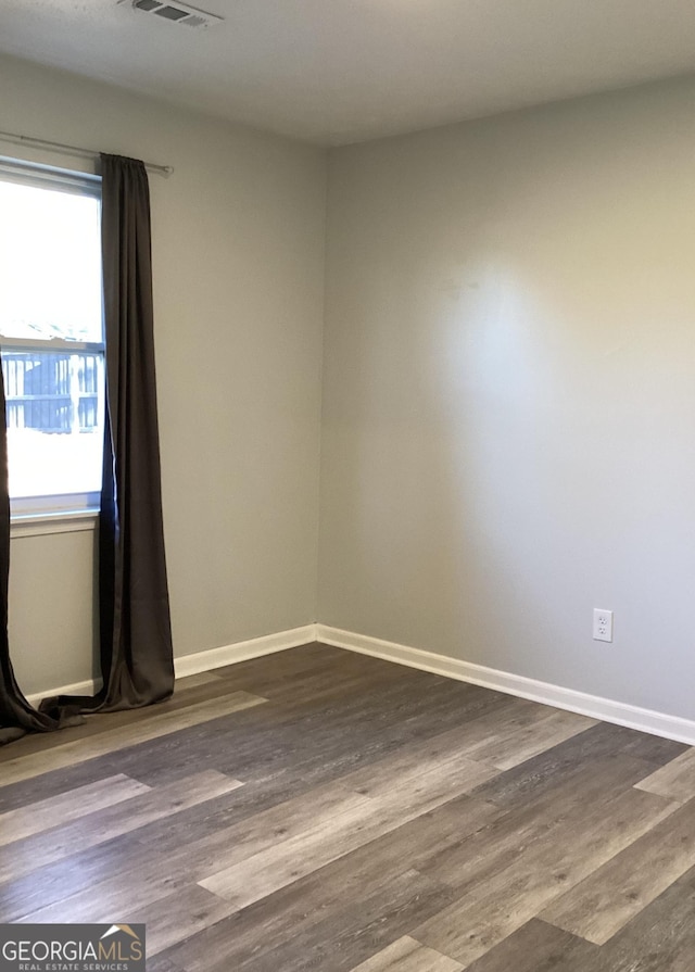 empty room with hardwood / wood-style floors and a wealth of natural light