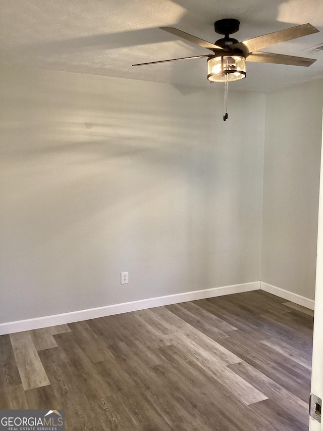 spare room with dark hardwood / wood-style floors and ceiling fan