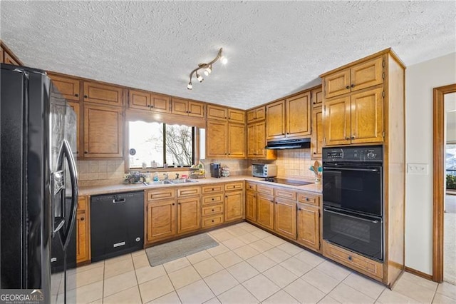 kitchen featuring light tile patterned floors, sink, backsplash, and black appliances