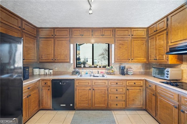 kitchen featuring tasteful backsplash, sink, light tile patterned floors, and black appliances