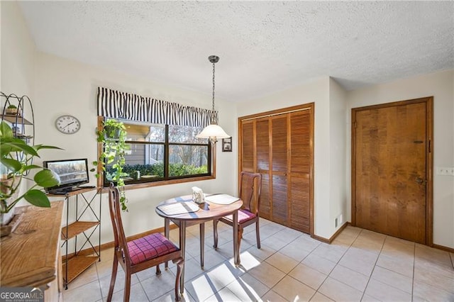 tiled dining space with a textured ceiling