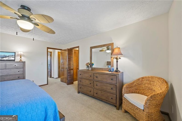 bedroom with ceiling fan, light colored carpet, and a textured ceiling