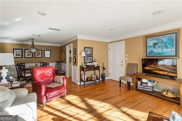 living room featuring ornamental molding and light hardwood / wood-style flooring