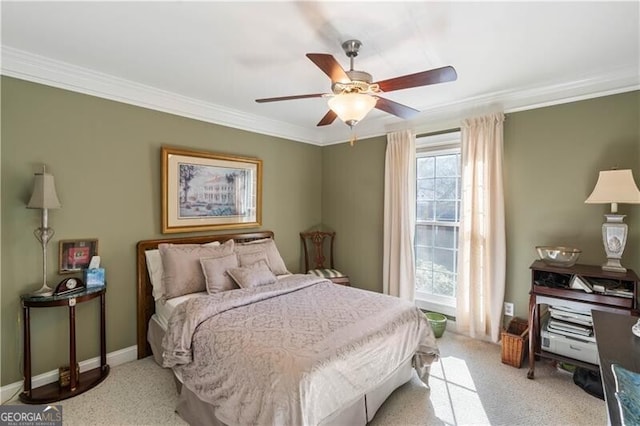 carpeted bedroom featuring ceiling fan and crown molding