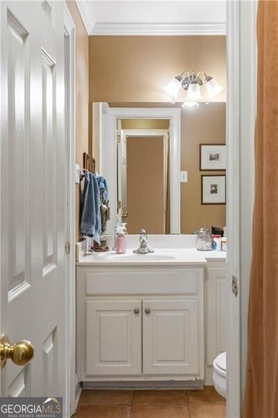 bathroom featuring tile patterned floors, vanity, toilet, and ornamental molding