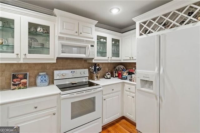 kitchen with white cabinets, light wood-type flooring, white appliances, and backsplash