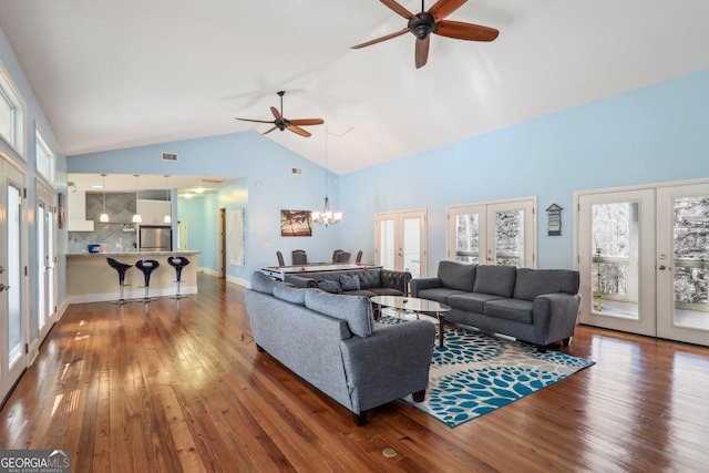 living room featuring dark hardwood / wood-style flooring, ceiling fan with notable chandelier, french doors, and high vaulted ceiling