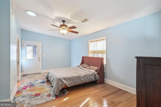 bedroom with ceiling fan, vaulted ceiling, and light wood-type flooring