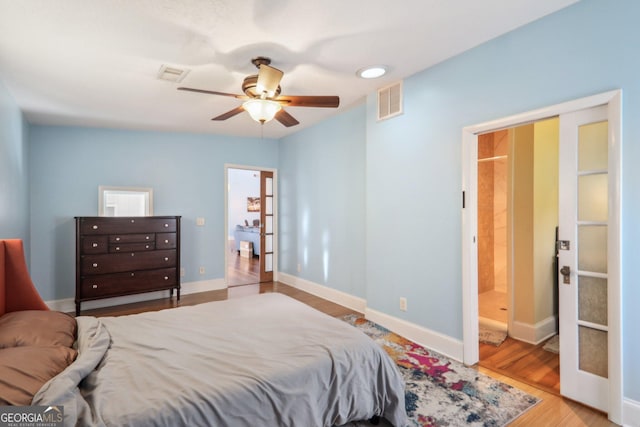 bedroom with ceiling fan, light hardwood / wood-style floors, and connected bathroom