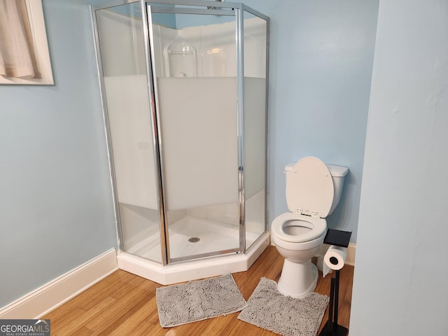 bathroom featuring toilet, hardwood / wood-style floors, and walk in shower