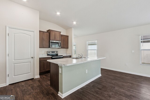 kitchen featuring appliances with stainless steel finishes, dark hardwood / wood-style flooring, vaulted ceiling, a kitchen island with sink, and sink