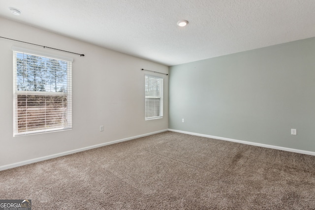 carpeted empty room with a textured ceiling