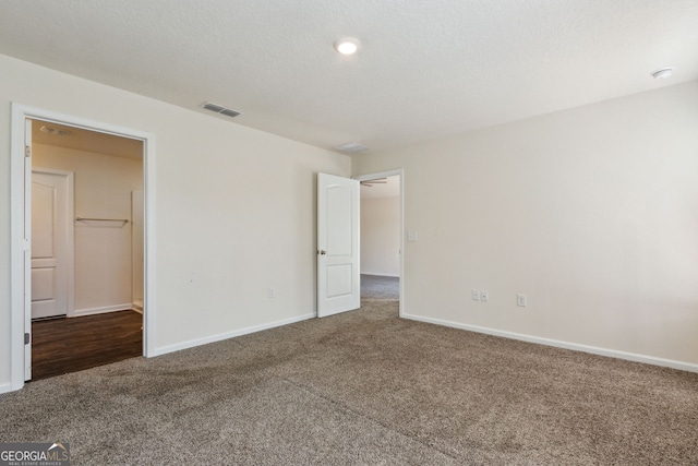 unfurnished bedroom featuring carpet flooring and a spacious closet