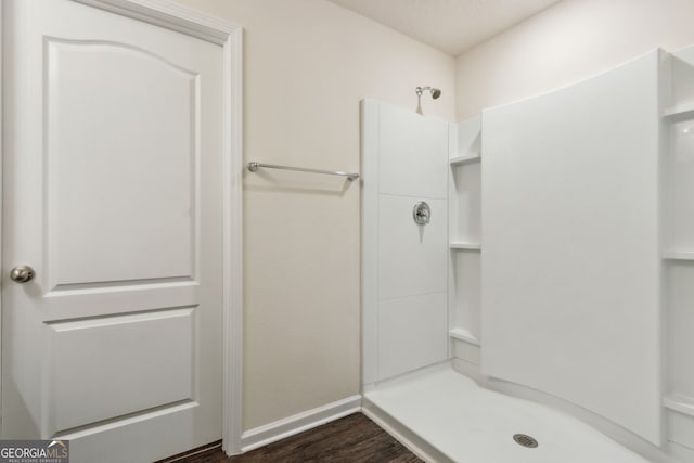 bathroom with a shower and hardwood / wood-style floors