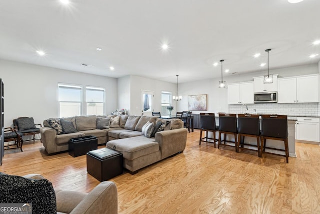 living room with a chandelier and light hardwood / wood-style floors