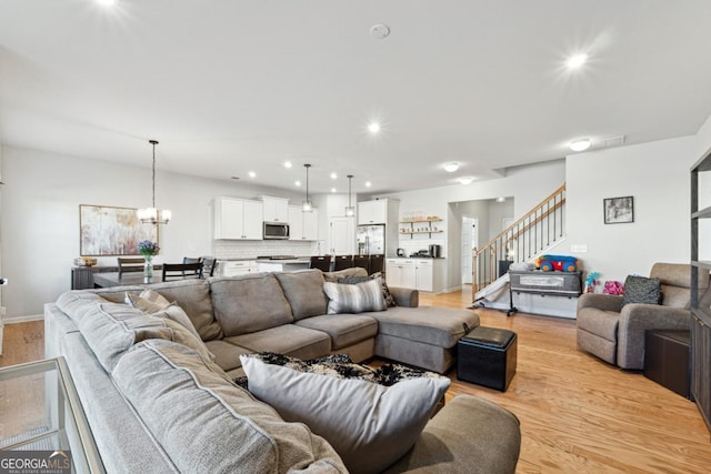 living room with light wood-type flooring and a chandelier