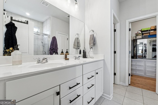 bathroom featuring tile patterned flooring, vanity, a shower with shower door, and a wealth of natural light