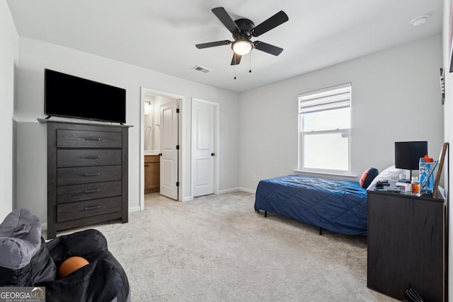 carpeted bedroom with ceiling fan and ensuite bathroom