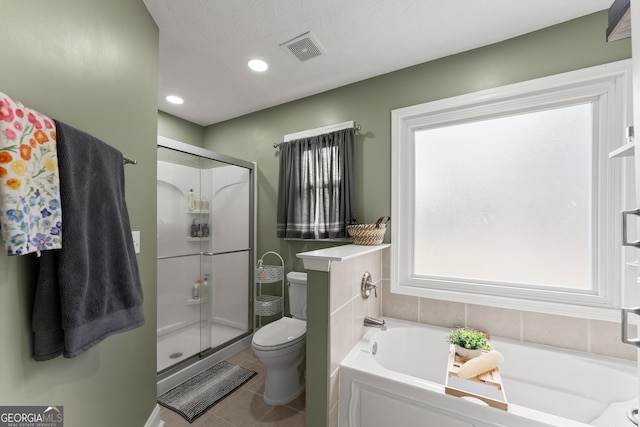 bathroom with toilet, tile patterned flooring, shower with separate bathtub, and a textured ceiling