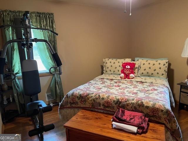 bedroom with dark hardwood / wood-style flooring