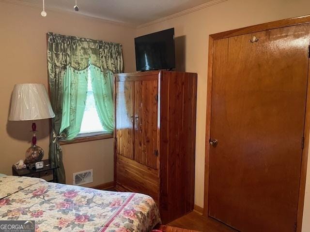 bedroom featuring hardwood / wood-style floors and crown molding