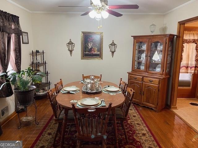 dining space with ceiling fan, ornamental molding, and dark hardwood / wood-style floors