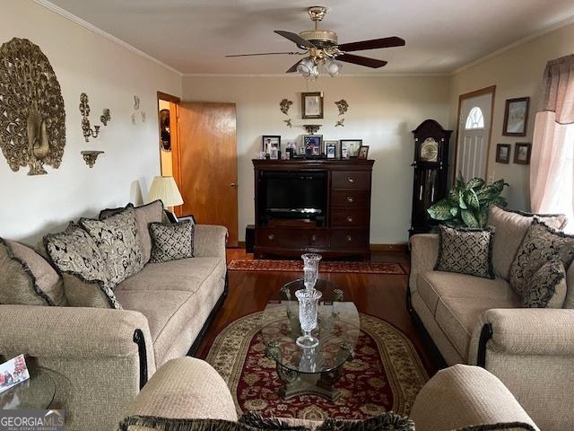 living room with ceiling fan, crown molding, and dark wood-type flooring