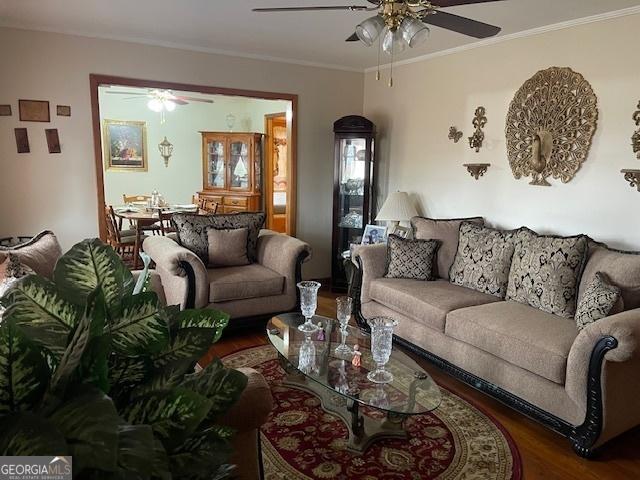 living room featuring ceiling fan, ornamental molding, and hardwood / wood-style flooring