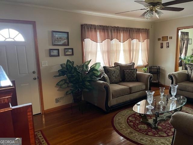 living room featuring ceiling fan, crown molding, and dark hardwood / wood-style floors