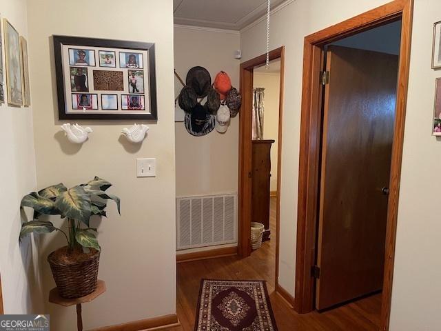 hall featuring crown molding and dark hardwood / wood-style floors