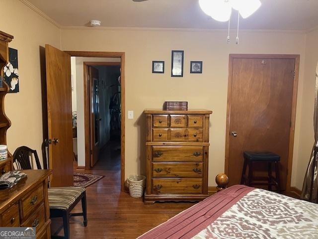 bedroom featuring ornamental molding and dark wood-type flooring