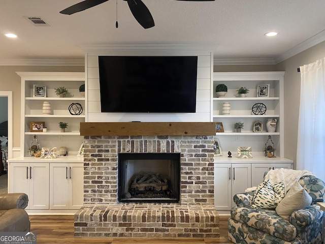 living room featuring crown molding, a fireplace, ceiling fan, and dark wood-type flooring