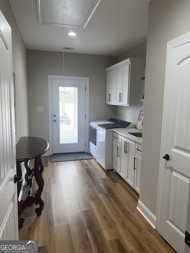 washroom featuring cabinets, dark hardwood / wood-style flooring, and washer and clothes dryer