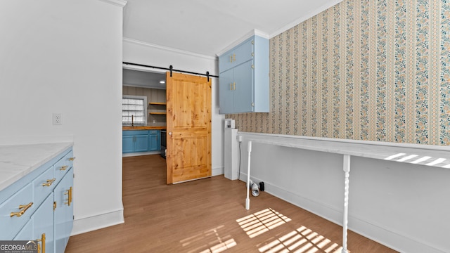 interior space with dark hardwood / wood-style flooring, a barn door, crown molding, and sink