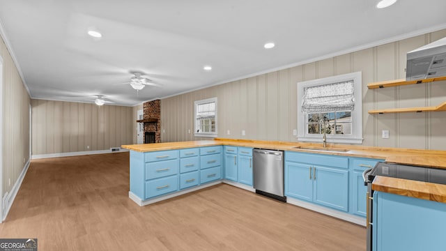 kitchen featuring wooden counters, crown molding, sink, a brick fireplace, and stainless steel dishwasher