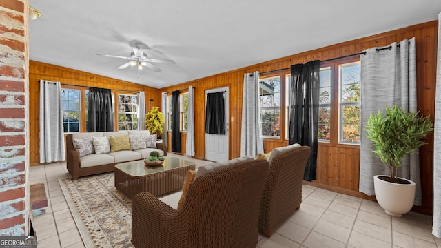 living room with plenty of natural light, light tile patterned floors, and wooden walls