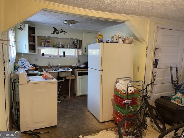 kitchen featuring concrete flooring, a textured ceiling, sink, white refrigerator, and washer / dryer