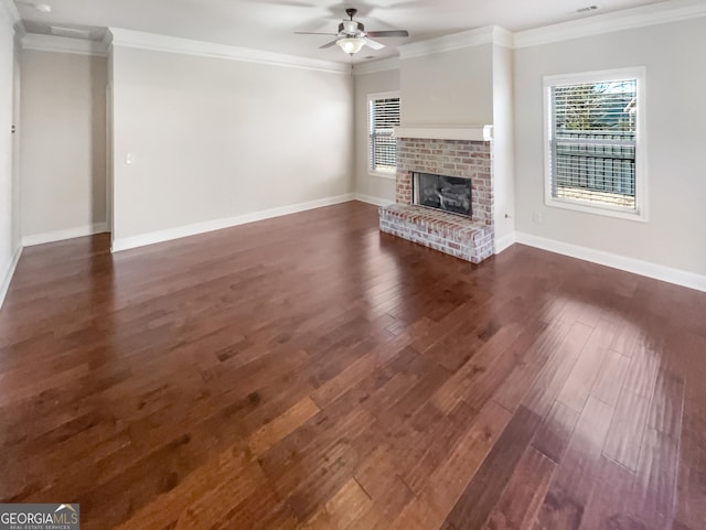 unfurnished living room featuring a wealth of natural light, crown molding, and a brick fireplace