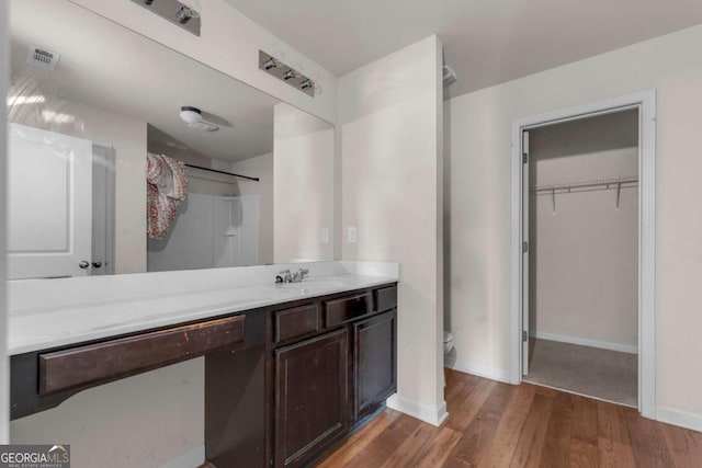 bathroom with vanity, toilet, wood-type flooring, and a shower