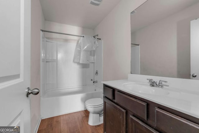 full bathroom with hardwood / wood-style floors, vanity, shower / bath combo, and toilet