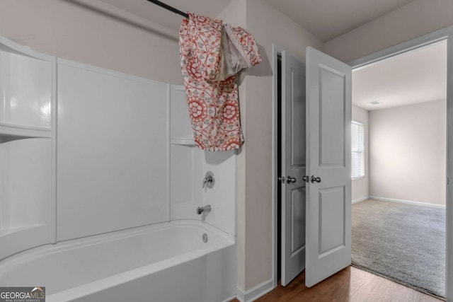 bathroom with hardwood / wood-style floors and shower / tub combo