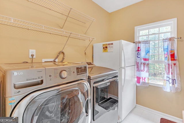 laundry room with washing machine and dryer and a wealth of natural light