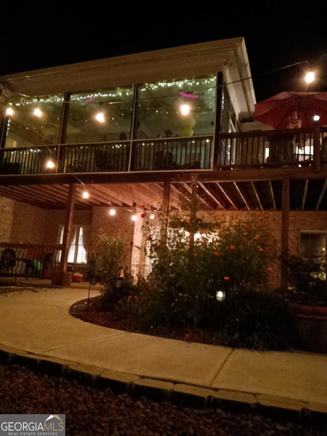 patio at twilight featuring a deck