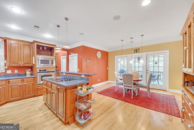 kitchen featuring a kitchen island, light hardwood / wood-style flooring, appliances with stainless steel finishes, and decorative light fixtures