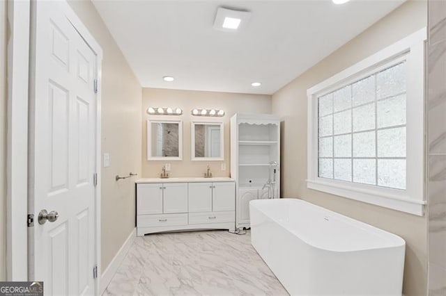 bathroom with a bathtub, vanity, and a healthy amount of sunlight